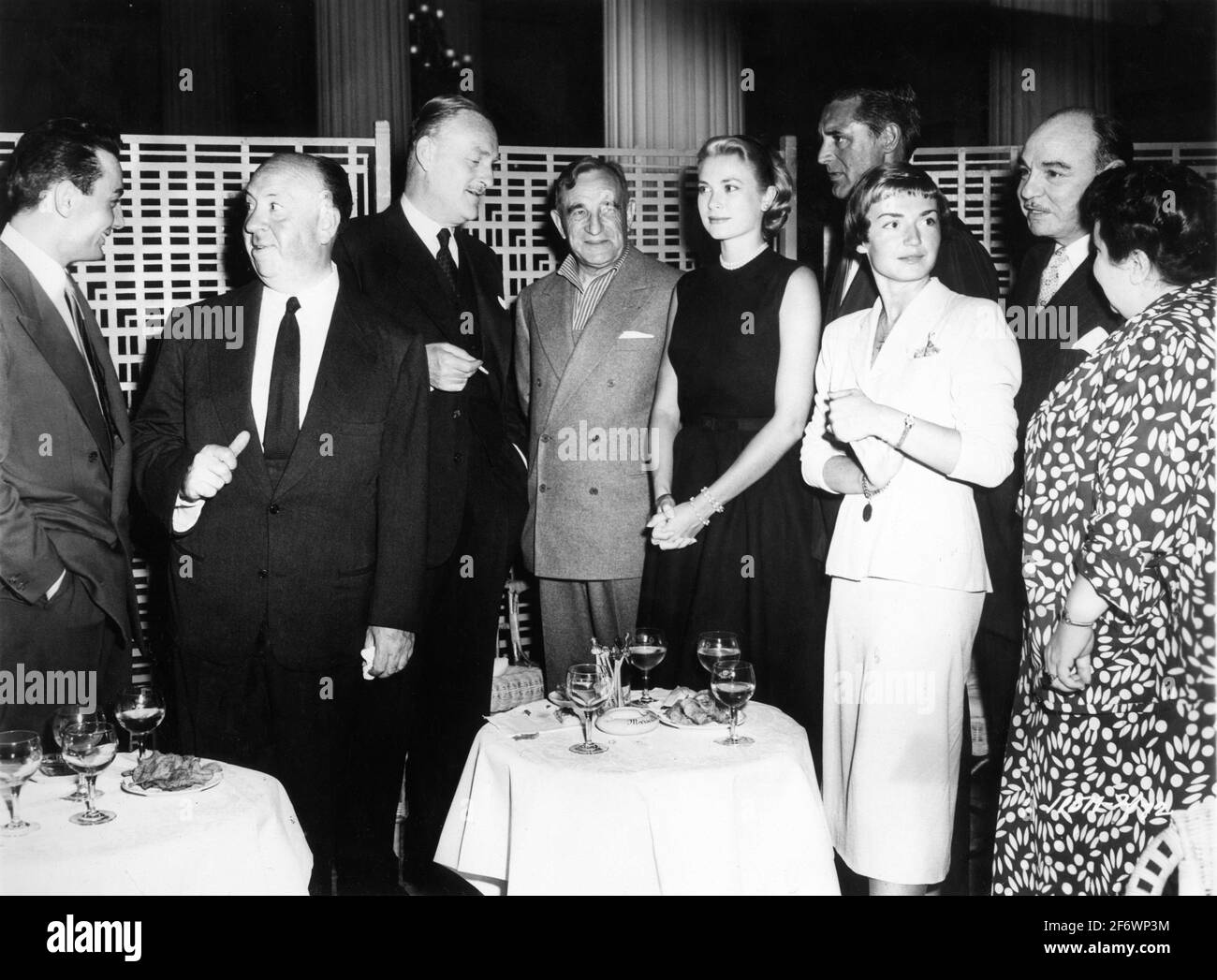 Réception de presse à Cannes en France pour la presse française avec de gauche ROLAND LESSAFRE , ALFRED HITCHCOCK , JOHN WILLIAMS, CHARLES VANEL , GRACE KELLY , CARY GRANT, BRIGITTE AUBER RENÉ BLANCARD et GEORGETTE ANYS au début du tournage de POUR CAPTURER UN VOLEUR 1955 réalisateur ALFRED HITCHCOCK basé sur le roman de David Dodge scénario John Michael Hayes costumes Edith Head Paramount Pictures Banque D'Images