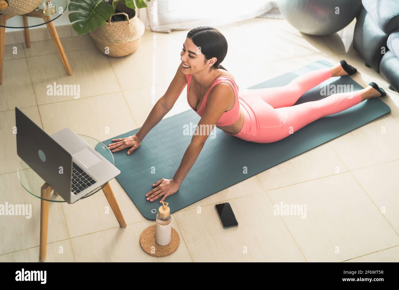 Jeune femme latine faisant pilates cours de fitness virtuel avec ordinateur portable À la maison - l'apprentissage en ligne et les gens bien-être concept de style de vie Banque D'Images