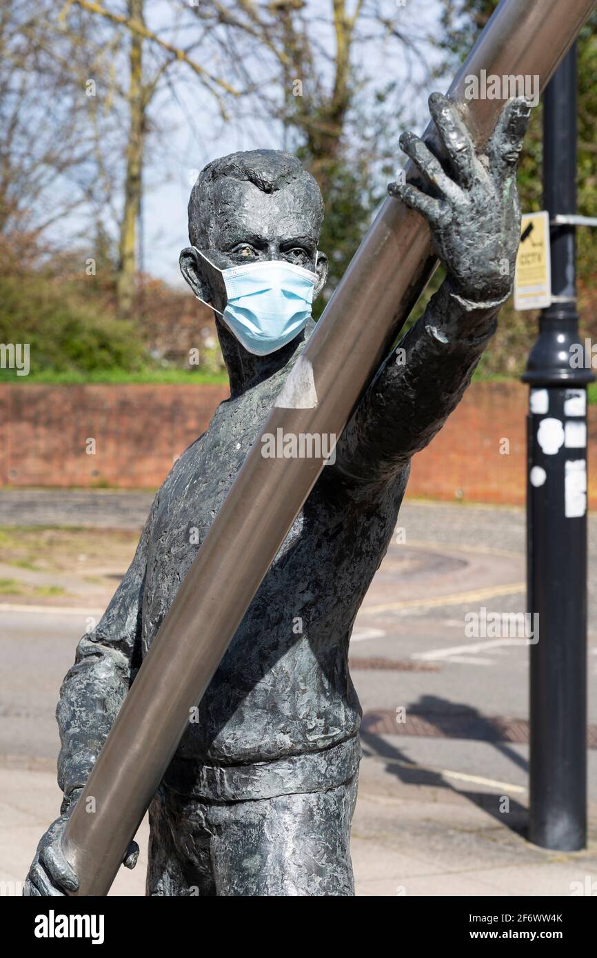 Statue d'un homme portant un masque médical bleu pendant la pandémie du coronavirus Covid-19 - l'une des deux figures de la sculpture de l'Arc. Basingstoke, Royaume-Uni Banque D'Images