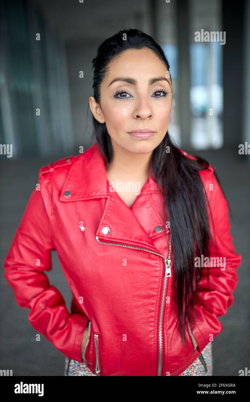 Gros plan d'une fille latina dans une veste rouge regardant l'appareil  photo Photo Stock - Alamy