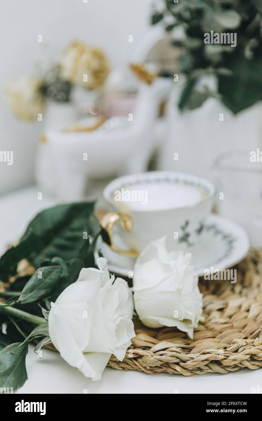 Tasse de café et roses blanches sur une table Banque D'Images