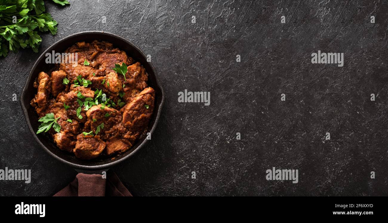 Ragoût de viande. Goulash de bœuf à la sauce végétale, vue du dessus, espace de copie. Viande braisée cuite lentement dans un moule en fonte. Banque D'Images