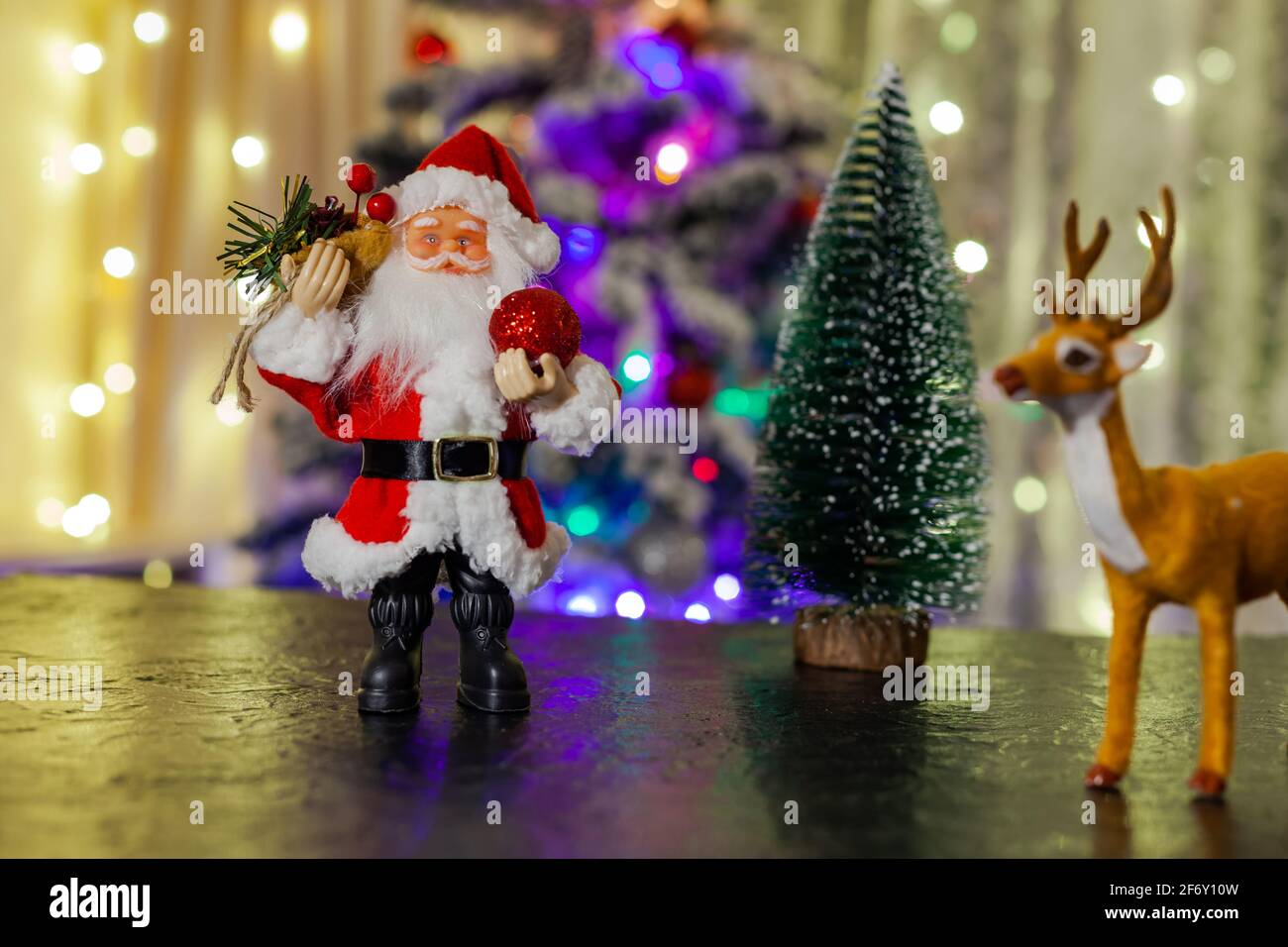 Le Père Noël et un petit arbre de Noël sur la vonne de guirlandes de lumières Banque D'Images