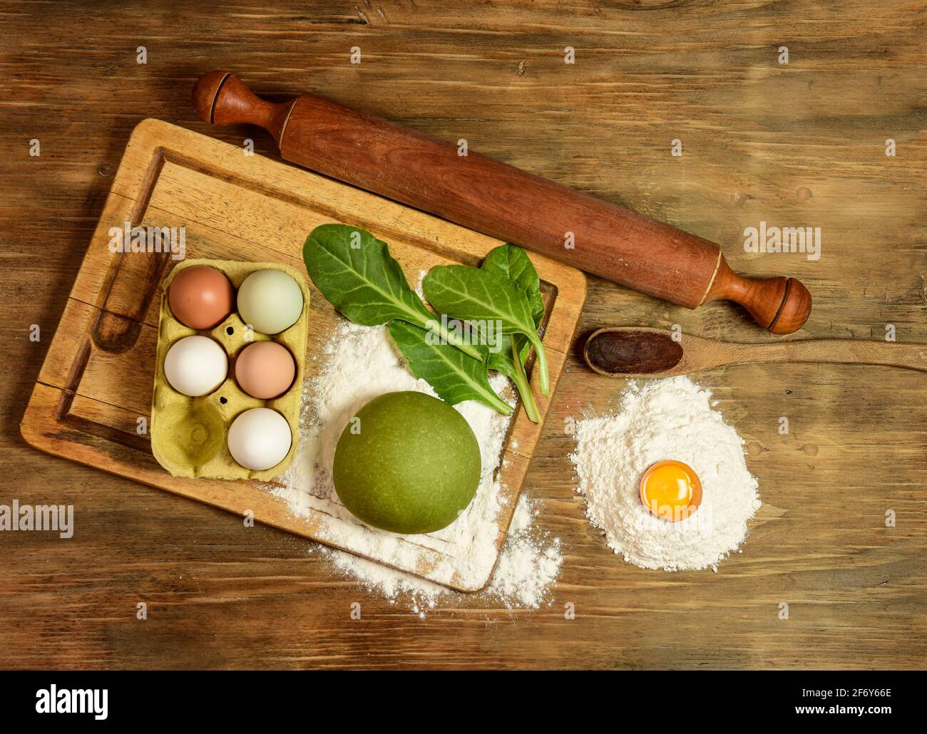 Pain à la pâte verte pour faire des nouilles, préparé sur la table avec des ingrédients, cuisine italienne traditionnelle Banque D'Images