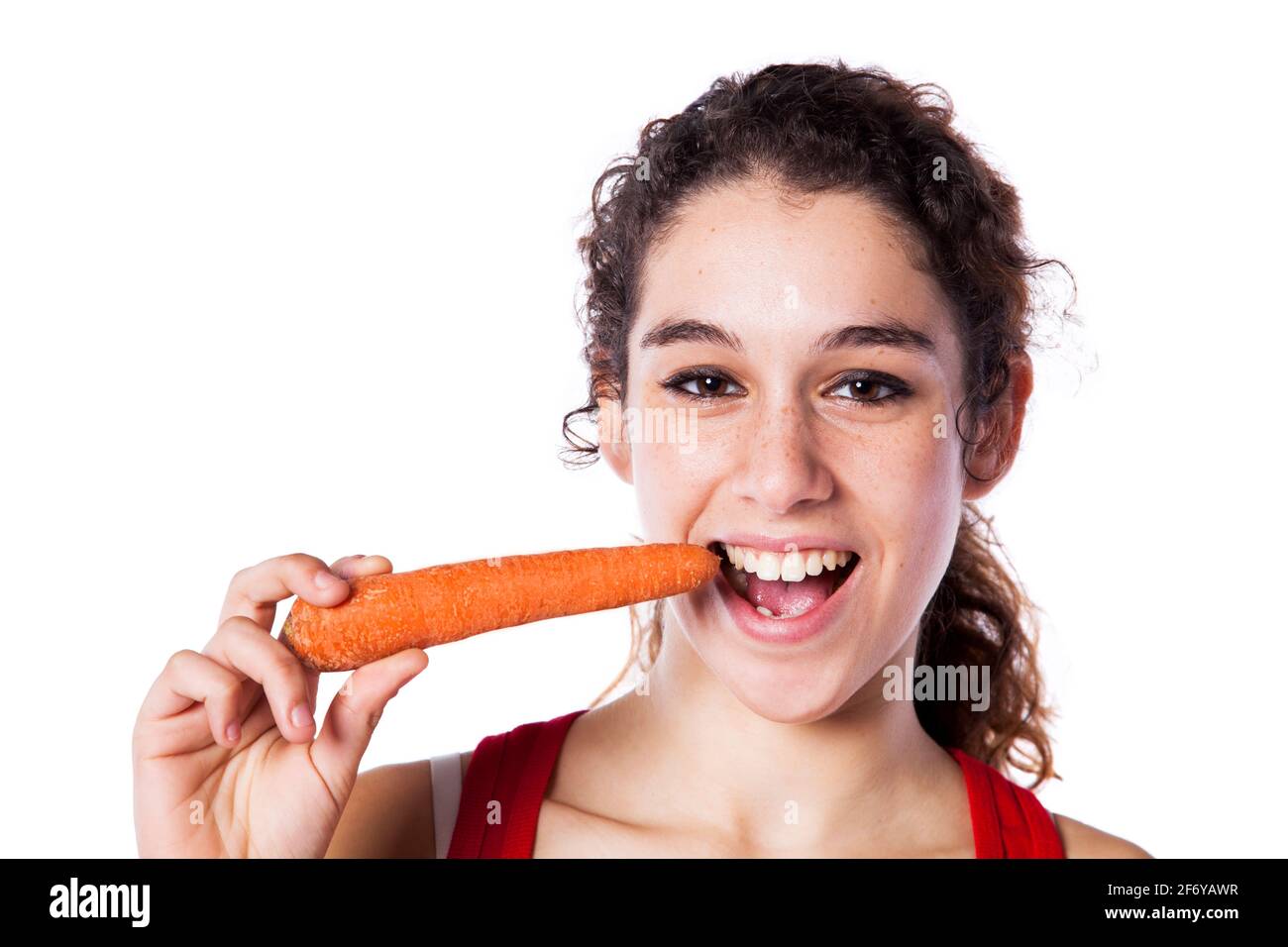 Bonne jeune femme mangeant une carotte (isolée sur blanc) Banque D'Images