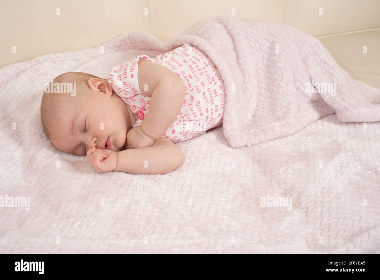 Bébé fille de deux mois dormant sur le côté Banque D'Images