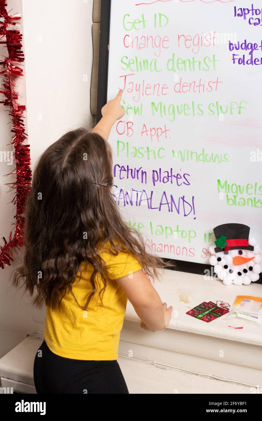 Tableau de motivation des tâches pour une fille de quatre ans, enfant pointant vers la tâche Banque D'Images