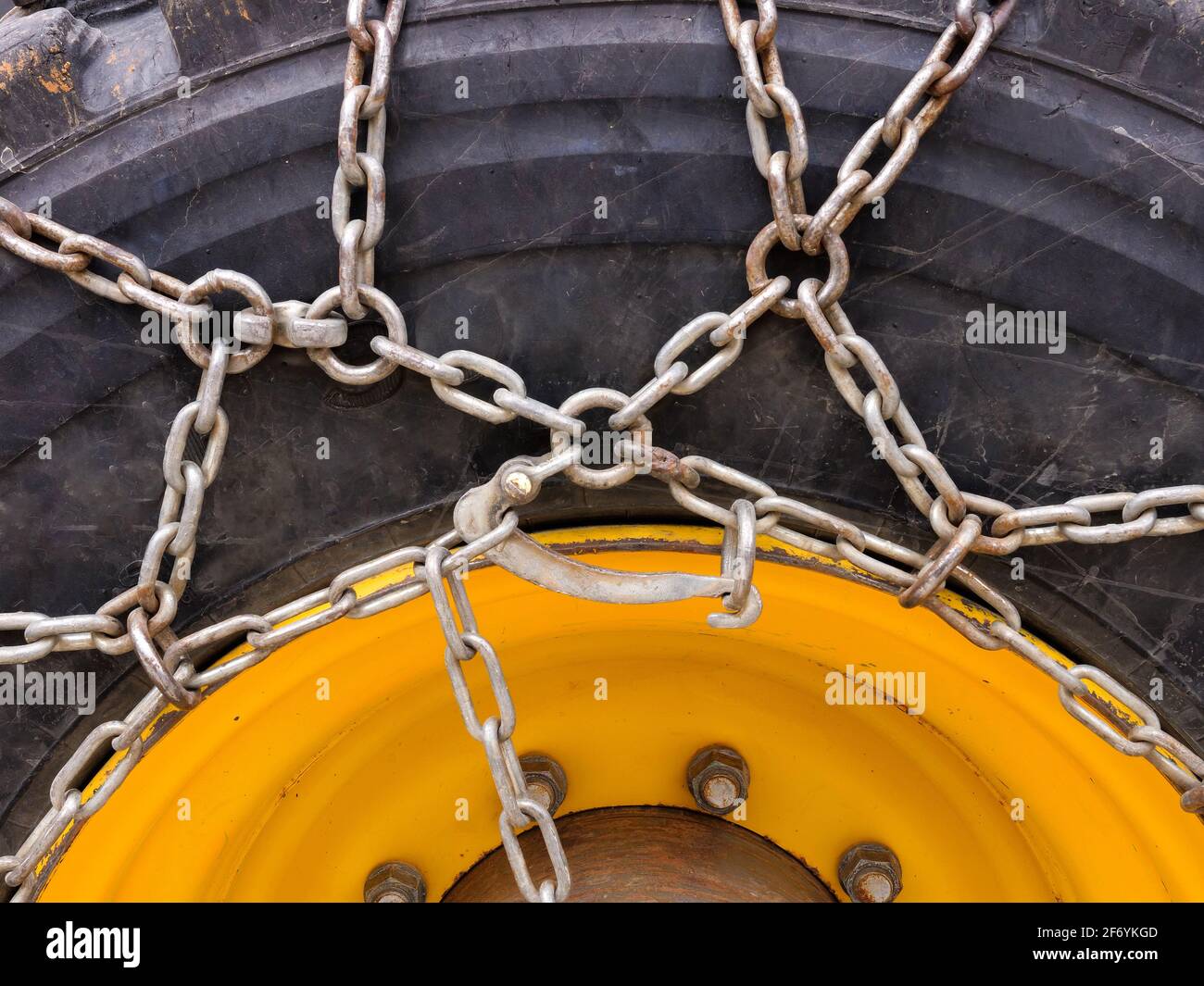 Roue du tracteur avec chaînes à neige, image de gros plan. Banque D'Images