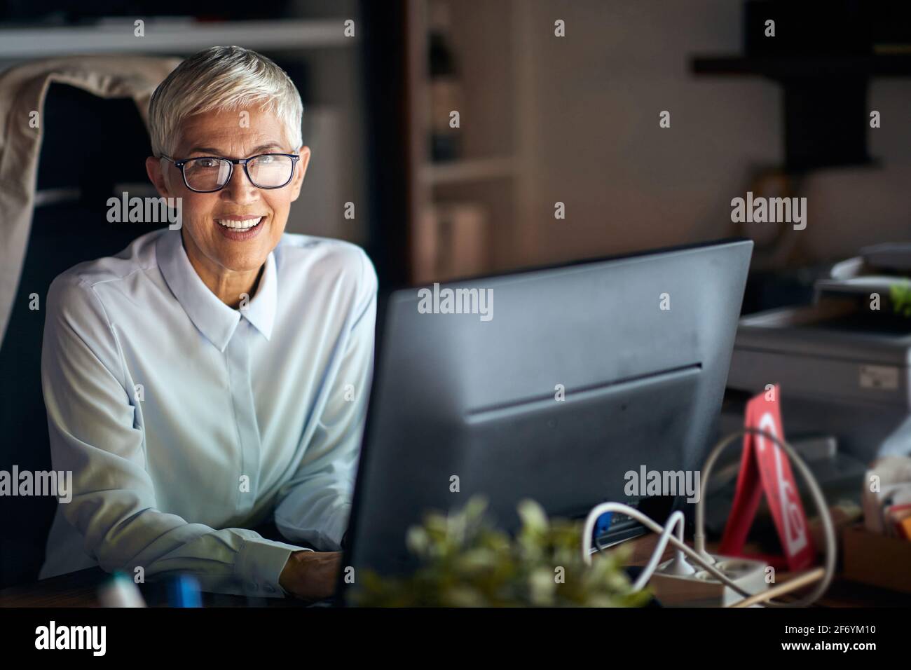Portrait d'une femme d'affaires haute heureuse travaillant au bureau Banque D'Images