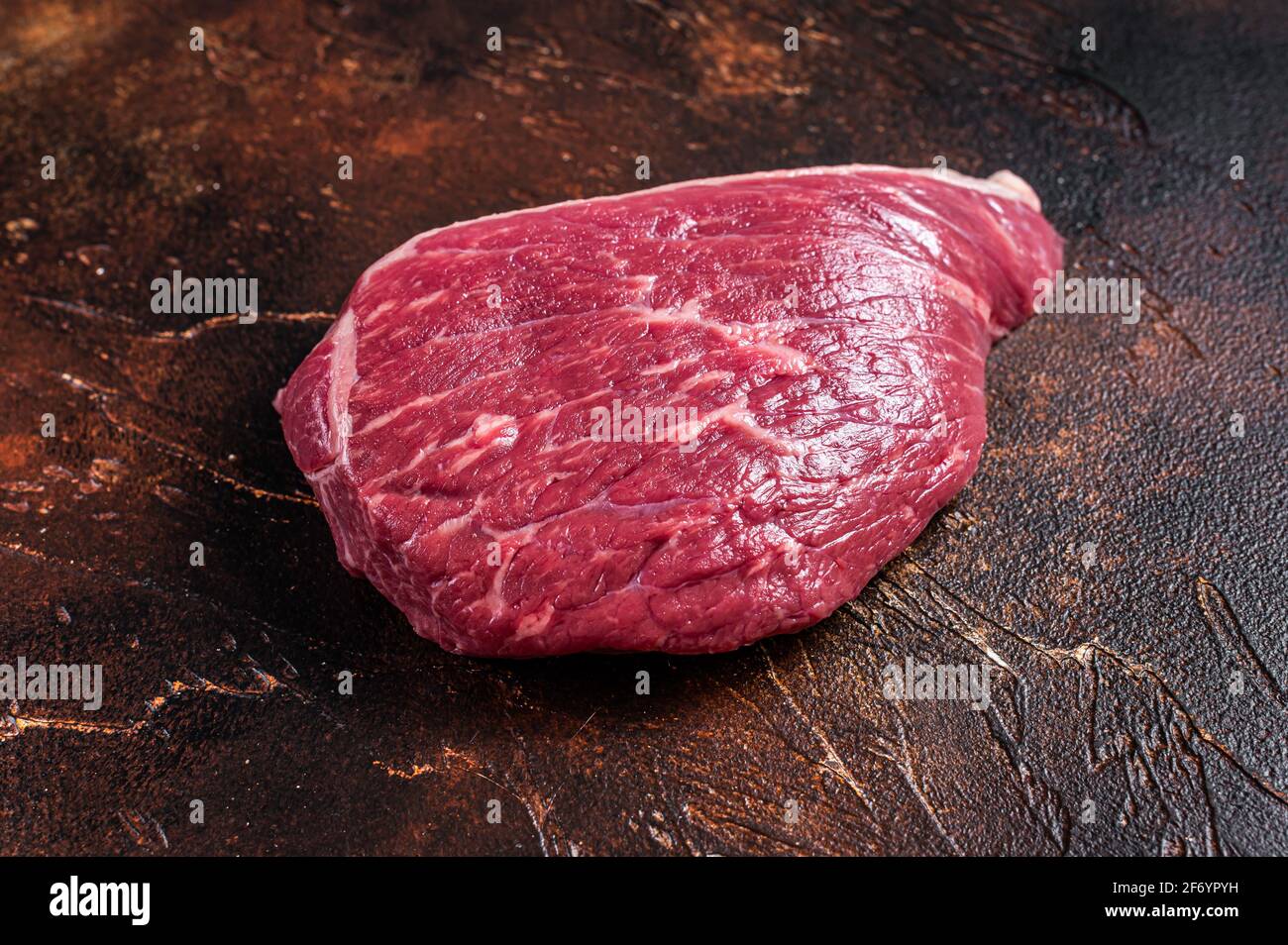Bœuf cru coupé ou steak de viande de sirloin sur la table de boucher. Arrière-plan sombre. Vue de dessus Banque D'Images