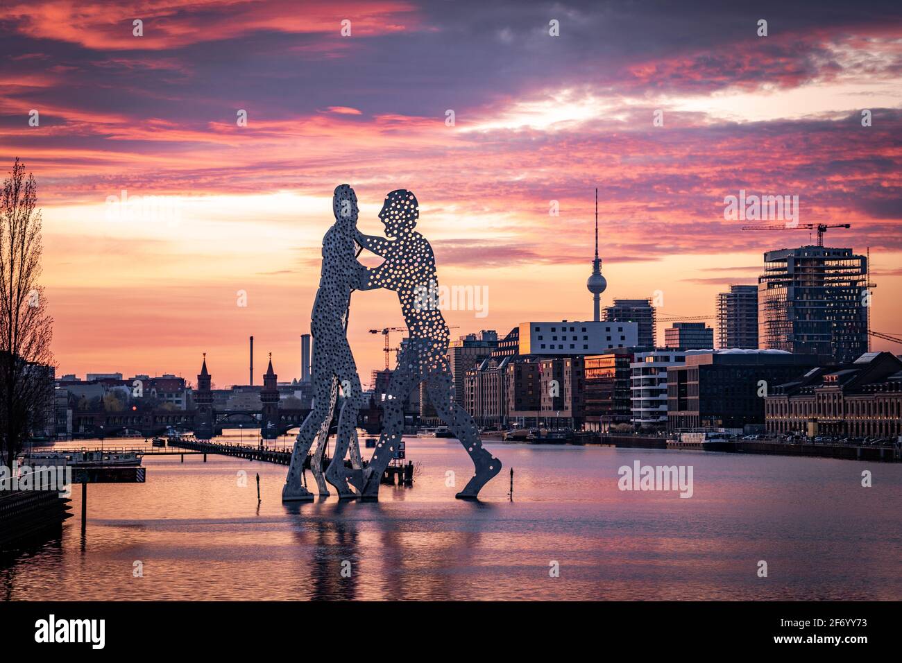 Statue de Molecule Man dans la rivière en forme de flèche avec vue sur la tour de télévision de berlin et le pont d'oberbaum Banque D'Images