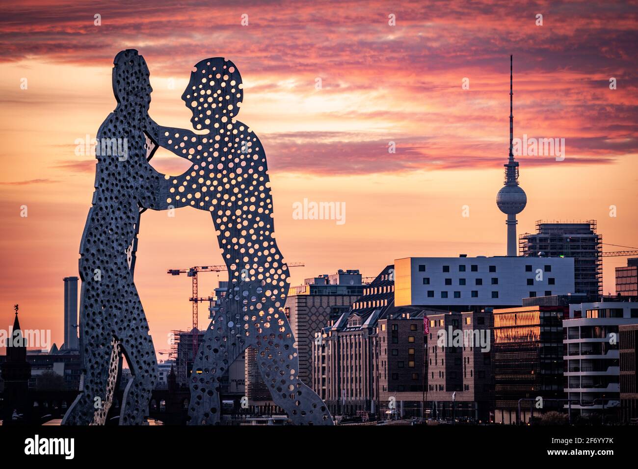Statue de Molecule Man avec tour tov de berlin en arrière-plan au coucher du soleil Banque D'Images