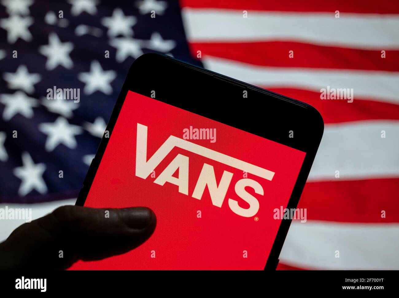Sur cette photo, le logo américain du fabricant de chaussures de skateboard  et de vêtements Vans est affiché sur un smartphone avec un drapeau des  États-Unis en arrière-plan Photo Stock - Alamy