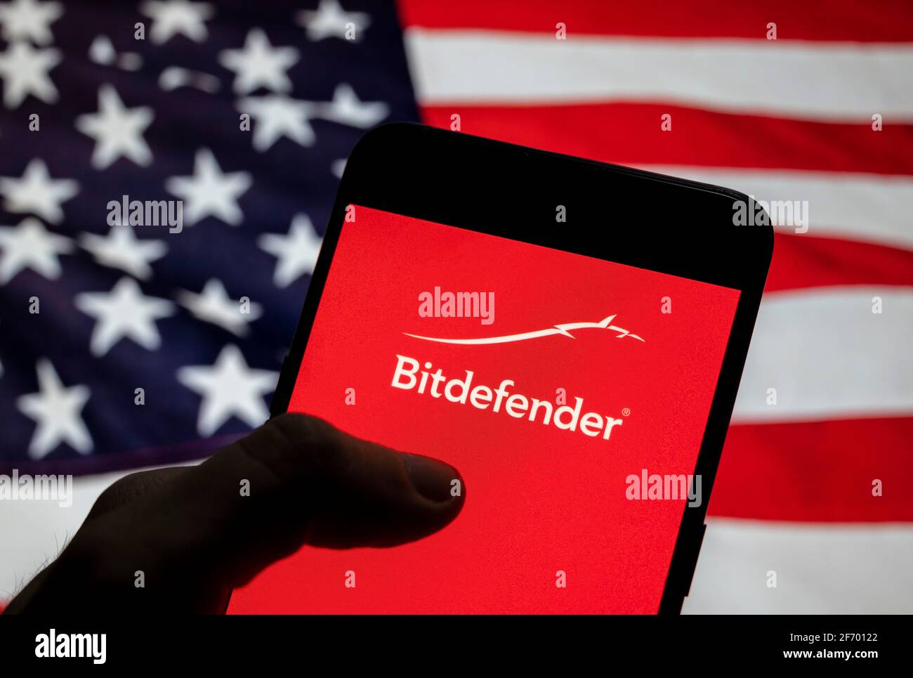 Sur cette photo, le logo de la société roumaine de cybersécurité et d'anti-virus Bitdefender est affiché sur un smartphone avec un drapeau des États-Unis en arrière-plan. Banque D'Images