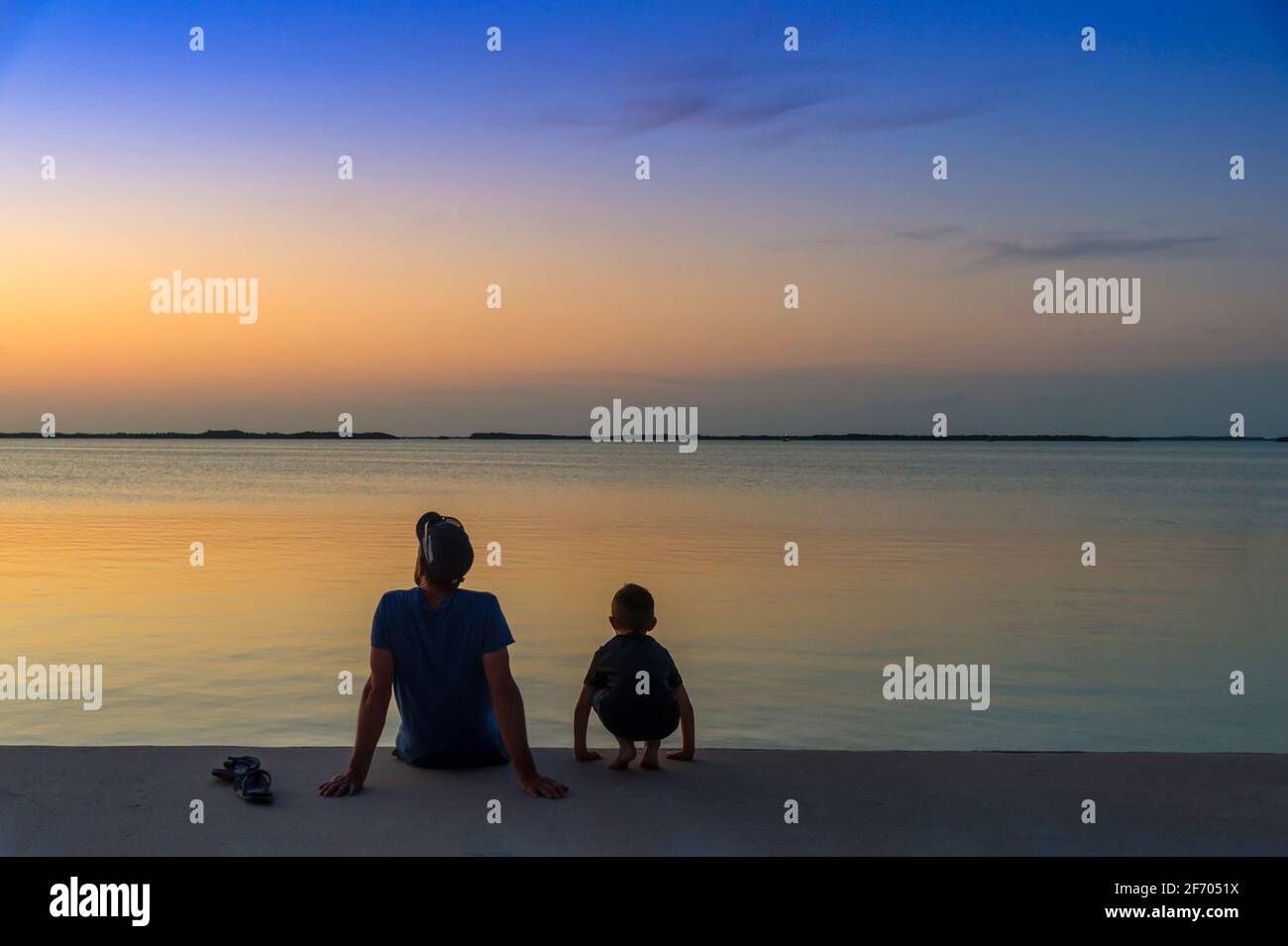 Père et fils regardant le coucher du soleil, Islamorada, Floride États-Unis Banque D'Images