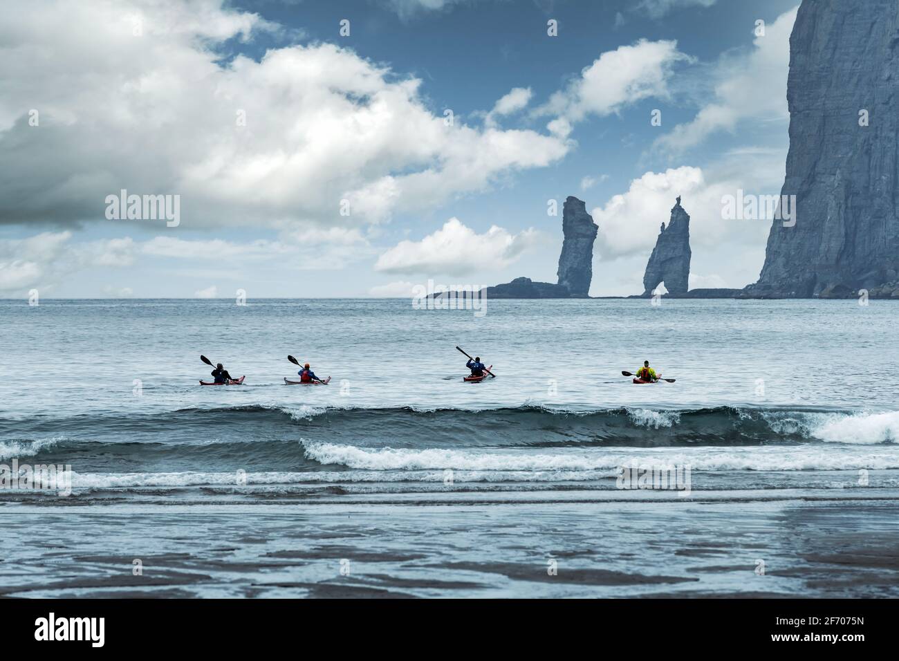 Quatre kayakistes sur la plage de Tjornuvik sur l'île de Streymoy, îles Féroé, Danemark. Photographie de paysage Banque D'Images
