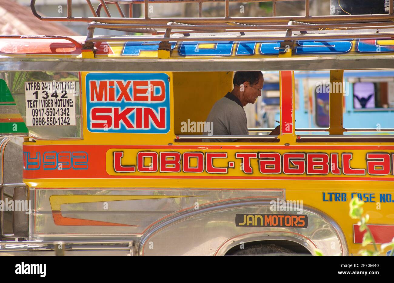 Philippin Jeeney sur l'île de Bohol, Central Visayas, Bohol, Philippines. Conducteur de jeepney encadré dans la fenêtre de jeepneys. Banque D'Images