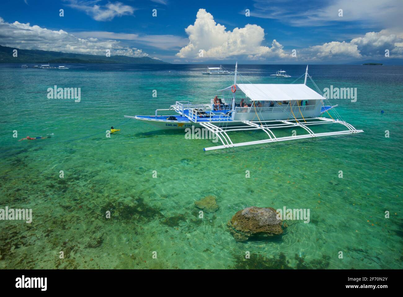 Diveboat dans les eaux au large de Moalboal, une station de plongée populaire sur l'île de Cebu, aux Philippines. Plage de Panagsama Banque D'Images
