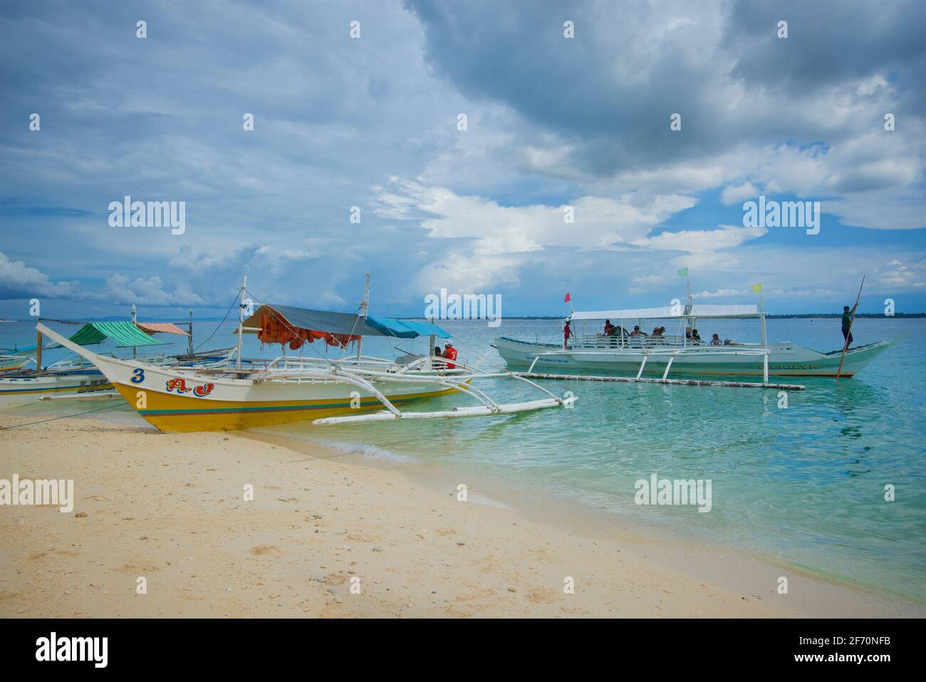 Canoës-outrigger sur une plage de sable. Utilisé pour transporter des visiteurs de Bantayan à Sillon (également connu sous le nom de « l'île vierge »), Cebu Phippines Banque D'Images