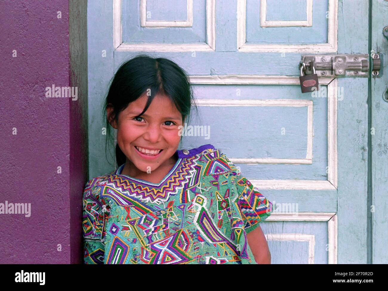 Ixil Maya fille devant les portes peintes de couleurs vives de la station de radio locale. Nebaj, triangle d'Ixil, El QuichŽ, Guatemala. Banque D'Images