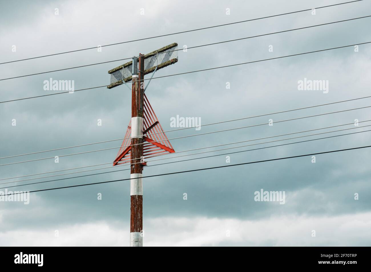 un triangle rouge monté sur un poteau, servant de marqueur d'avertissement visuel aux pilotes qui s'approchent d'un avion de la présence de lignes électriques Banque D'Images