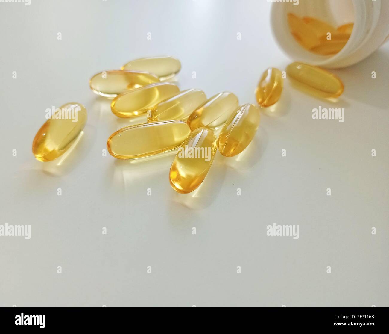 Capsules d'huile de poisson. Pilules médicinales de la pharmacie pour restaurer la santé. Capsules jaunes sur fond blanc. Banque D'Images