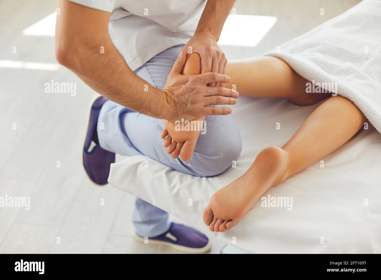 Masseuse professionnelle effectuant un massage des pieds pour la jeune femme dans moderne clinique de santé Banque D'Images