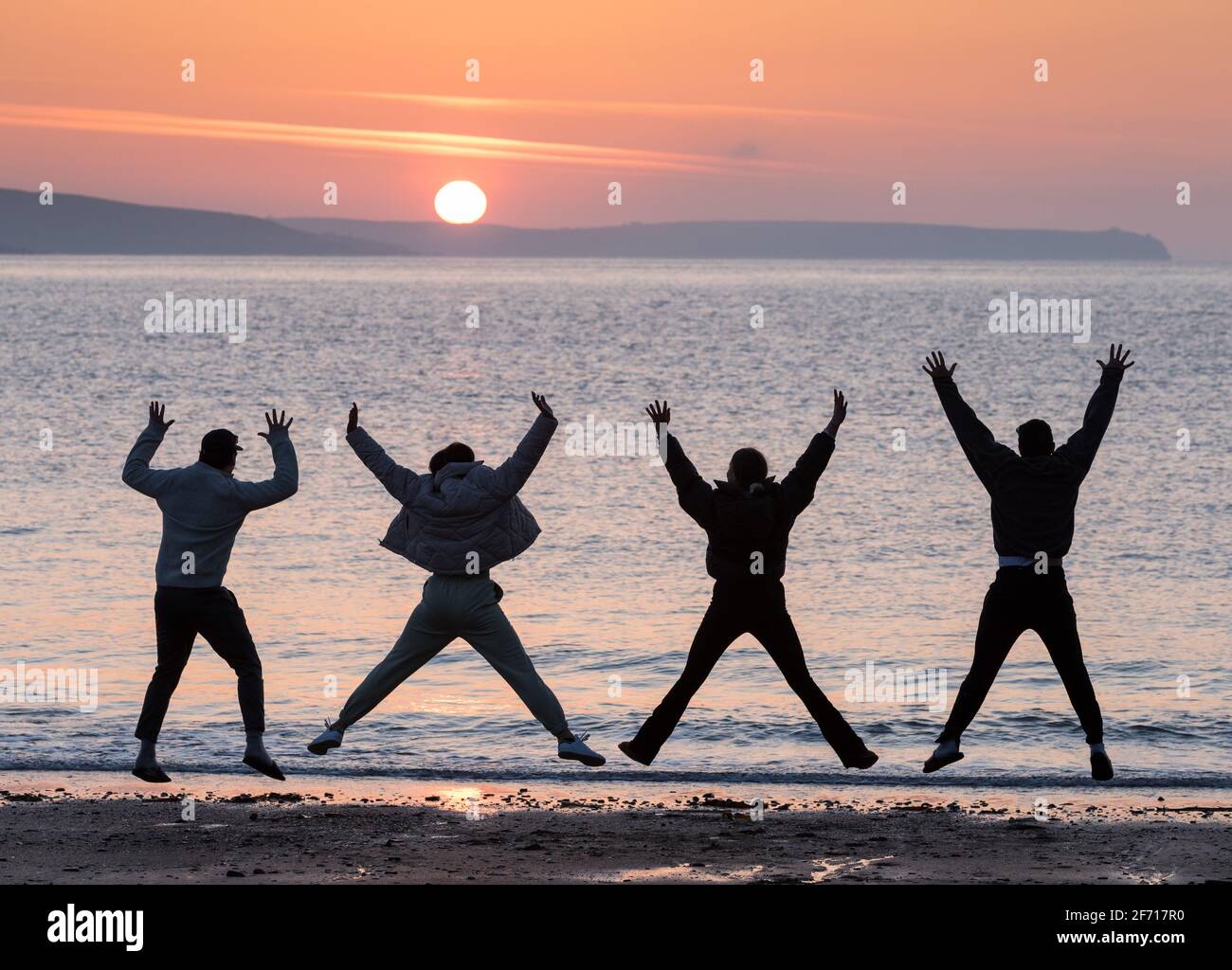 Myrtleville, Cork, Irlande. 04e avril 2021. Ryan Wortman, Evie Atkinson, Jennifer Greally et Ashkan Mehjoo sautent à l'arrivée du soleil levant le dimanche de Pâques à Myrtleville, Co. Cork, Irlande. - crédit; David Creedon / Alamy Live News Banque D'Images