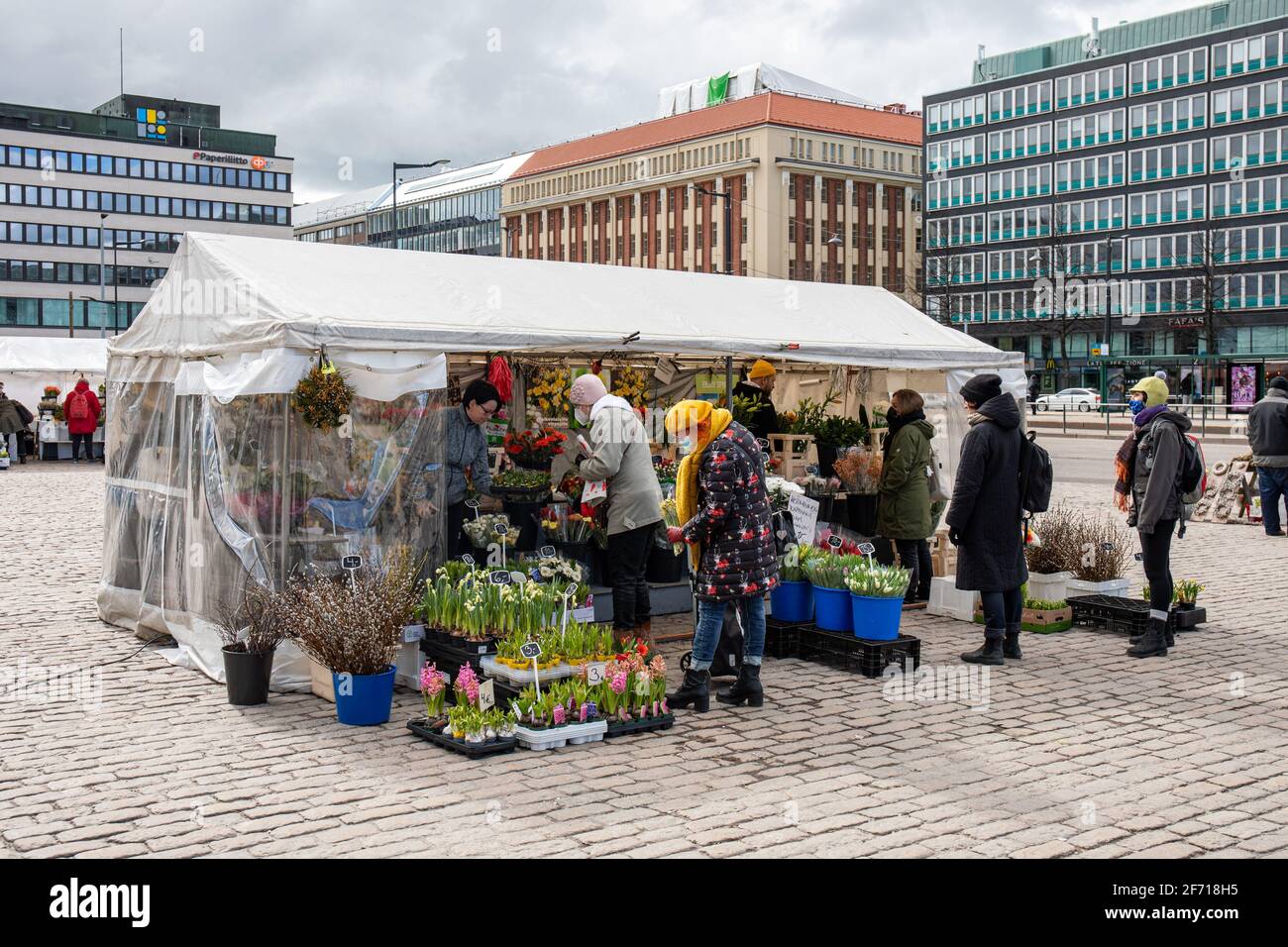Les gens qui achètent des fleurs coupées, des bouquets et des fleurs de balcon à la stalle de fleuriste couverte de marquise sur la place du marché Hakaniemi à Helsinki, en Finlande Banque D'Images