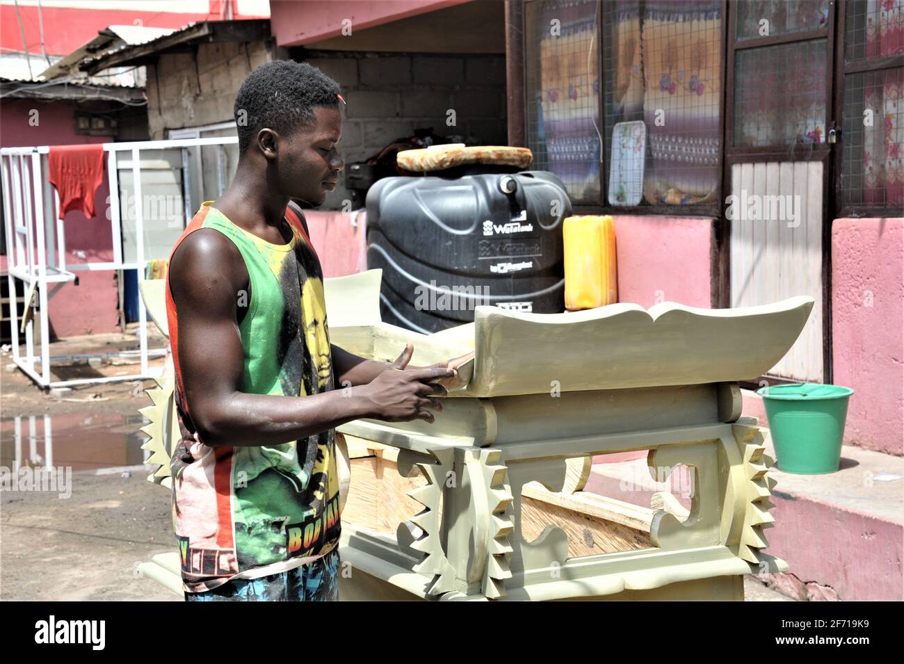Accra, Ghana. 23 mars 2021. Le Carpenter Lawrence Anang fait un cercueil lors d'un atelier de cercueil à Accra, capitale du Ghana, le 23 mars 2021. Les cercueils au Ghana pourraient non seulement être des boîtes qui contiennent le défunt, mais aussi des œuvres d'art qui varient en plusieurs styles, une façon unique pour les gens de commémorer leurs bien-aimés.ALLER AVEC 'la vedette: Le jeune charpentier ghanéen perpétue la tradition de faire des cercueils stylisés' Credit: Xu Zheng/Xinhua/Alay Live News Banque D'Images