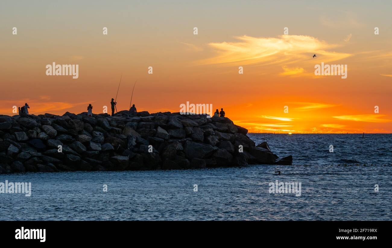 Des personnes non identifiées regardant le coucher du soleil sur Cottesloe Beach à Perth, en Australie occidentale. Banque D'Images