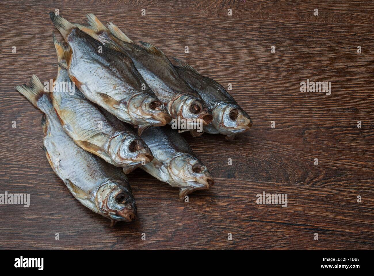 quelques poissons séchés sur un fond en bois foncé/ Banque D'Images