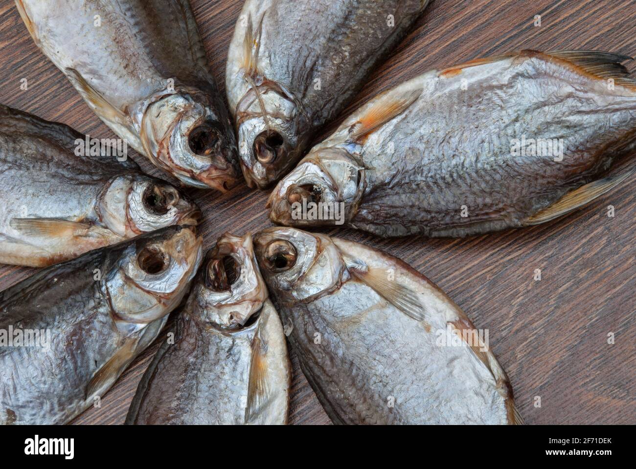 quelques poissons séchés sur un fond en bois foncé/ Banque D'Images