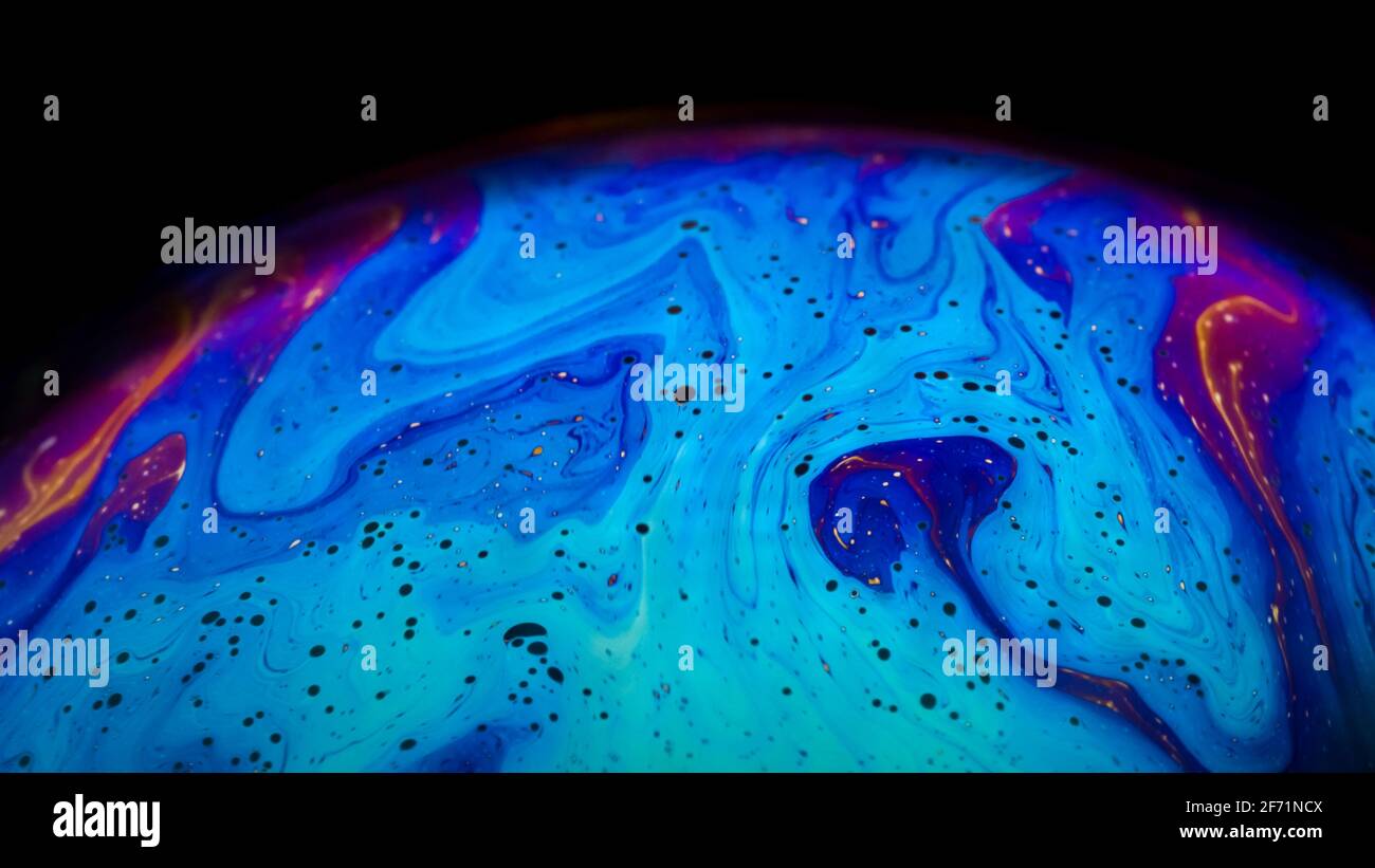 Bulle liquide de savon ressemblant à des planètes. Art abstrait psychédélique coloré avec des motifs de couleur urreaux mouvements. Banque D'Images