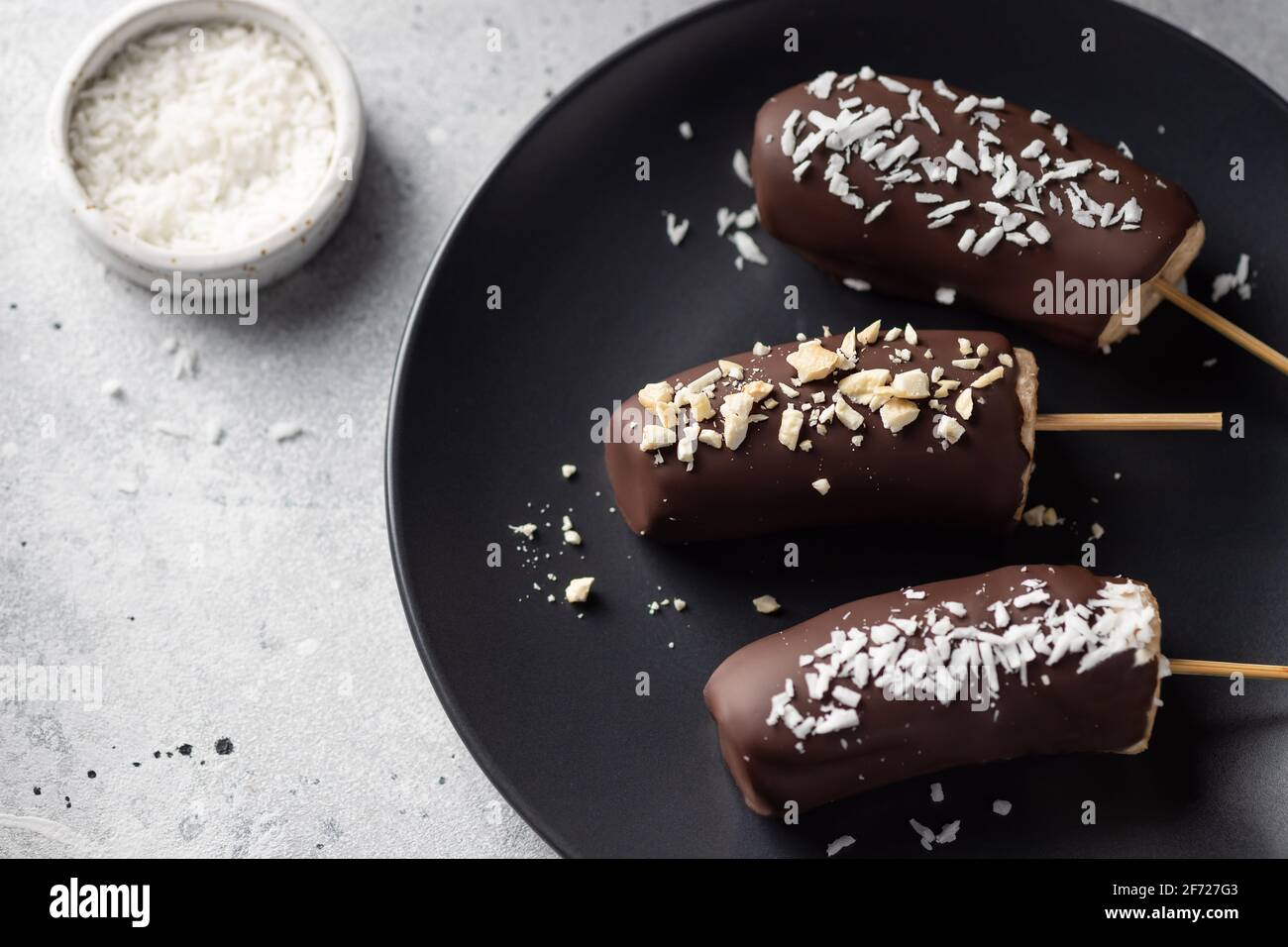 Bananes au chocolat noir avec noix et noix de coco Banque D'Images