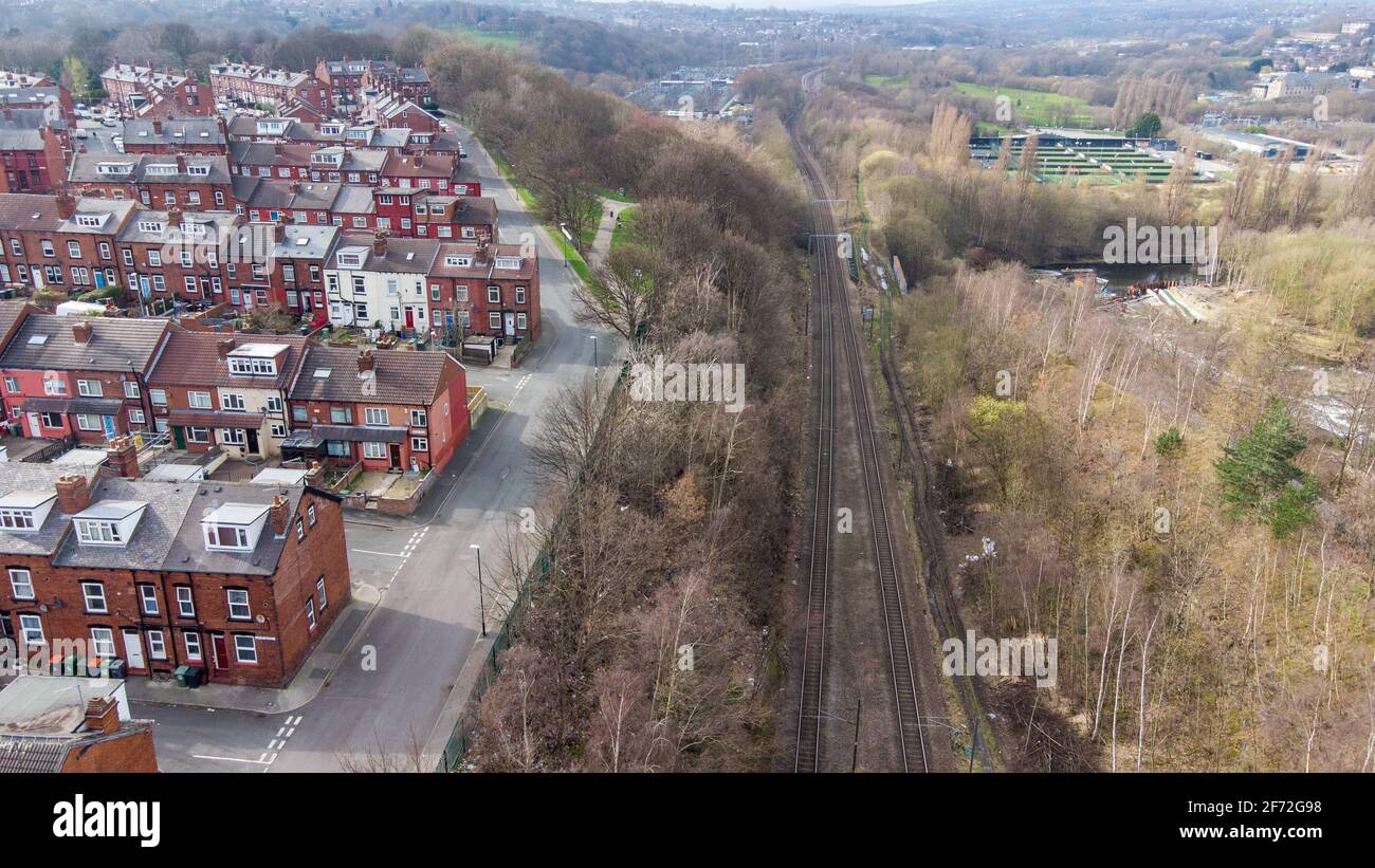 Photo aérienne du village de Kirkstall dans la ville De Leeds au Royaume-Uni montrant des rangées de maisons en terrasse le long d'une voie ferrée au printemps Banque D'Images