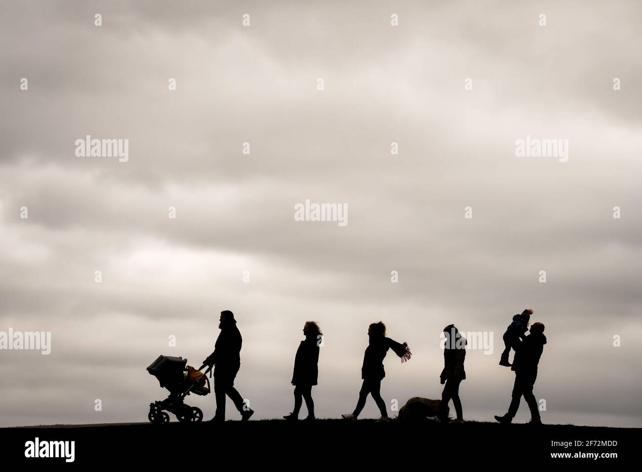 Dangast, Allemagne. 04e avril 2021. Une famille de plusieurs de Delmenhorst va pour une promenade avec tous leurs enfants le dimanche de Pâques sous le ciel couvert dans la ville thermale de Dangast sur la baie de Jade. Credit: Mohssen Assanimoghaddam/dpa/Alay Live News Banque D'Images