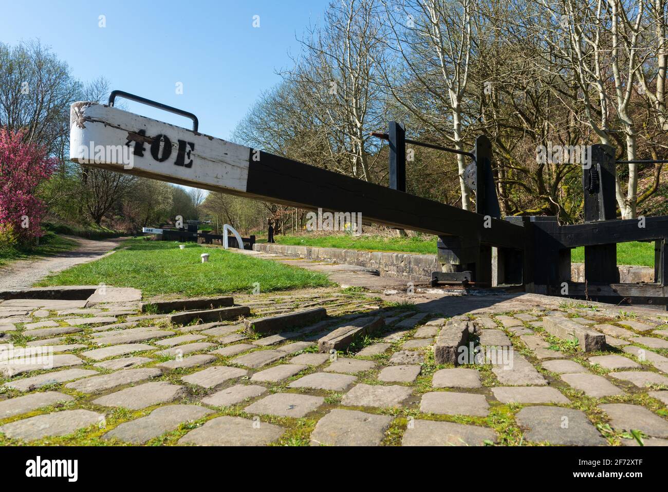 Vue ensoleillée sur le printemps d'une porte à écluses sur l'historique Huddersfield étroite canal à Marsden dans le West Yorkshire Banque D'Images