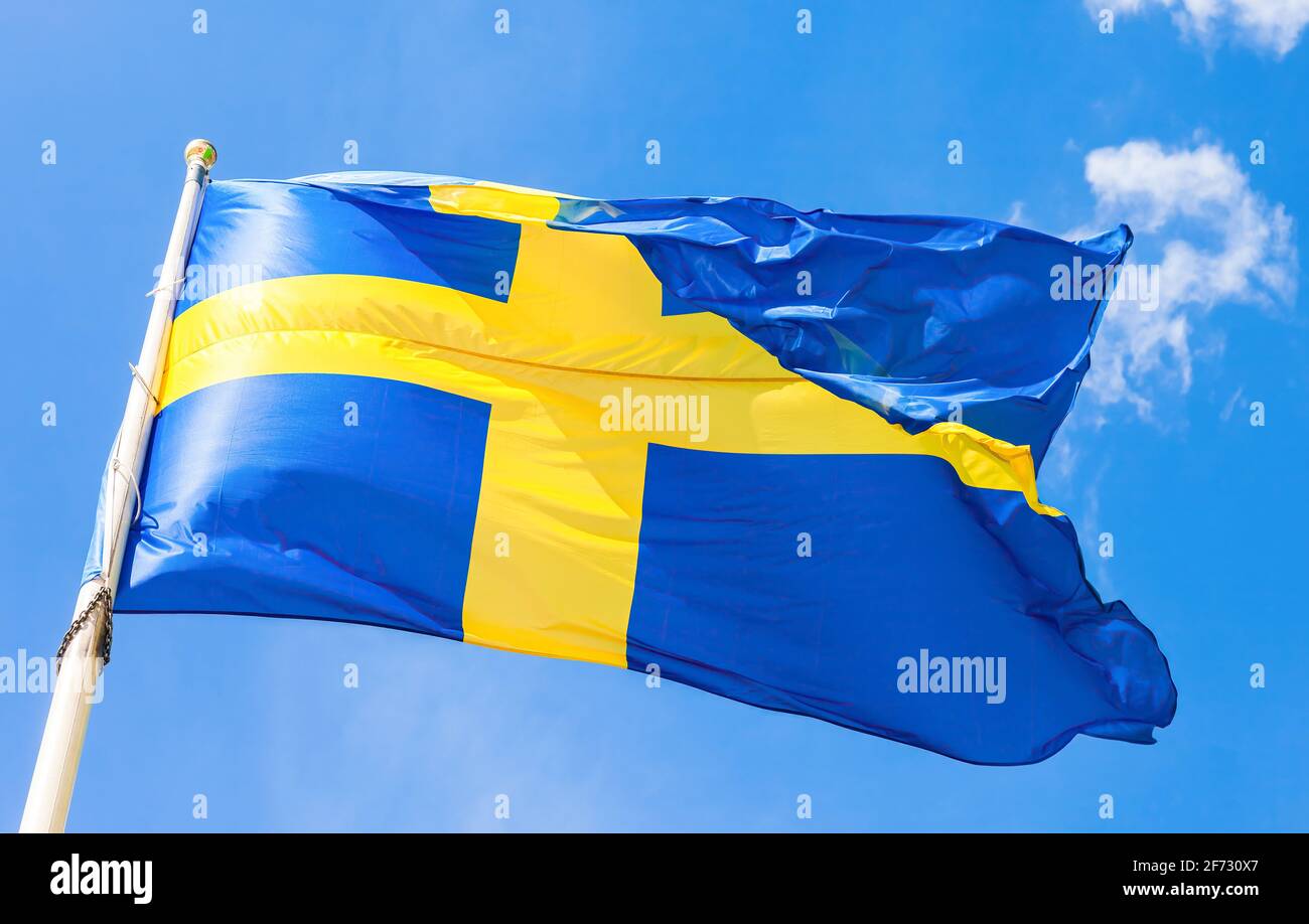 Drapeau Bleu Clair Et Jaune Drapeau suédois avec croix jaune agitant dans le vent contre le ciel bleu  Photo Stock - Alamy