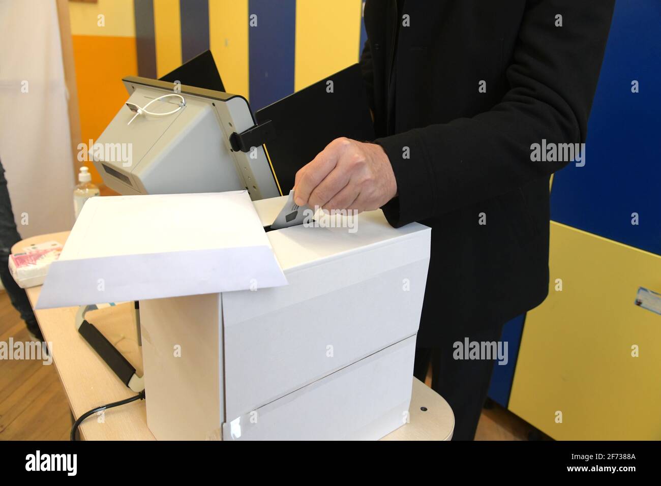 Sofia, Bulgarie - Apr 4 2021: Gros plan d'une femme mettant sa carte de vote dans une boîte après avoir voté électroniquement Banque D'Images