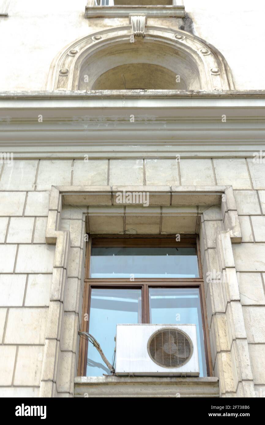 Grande fenêtre avec climatiseur installé dans le style néoclassique avec moulure sur le dessus, Bucarest, Roumanie Banque D'Images