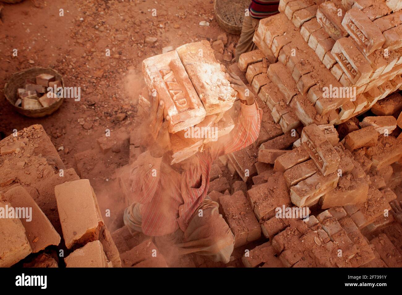 Un travailleur porte des briques au Brickfield à Khulna, au Bangladesh. Banque D'Images