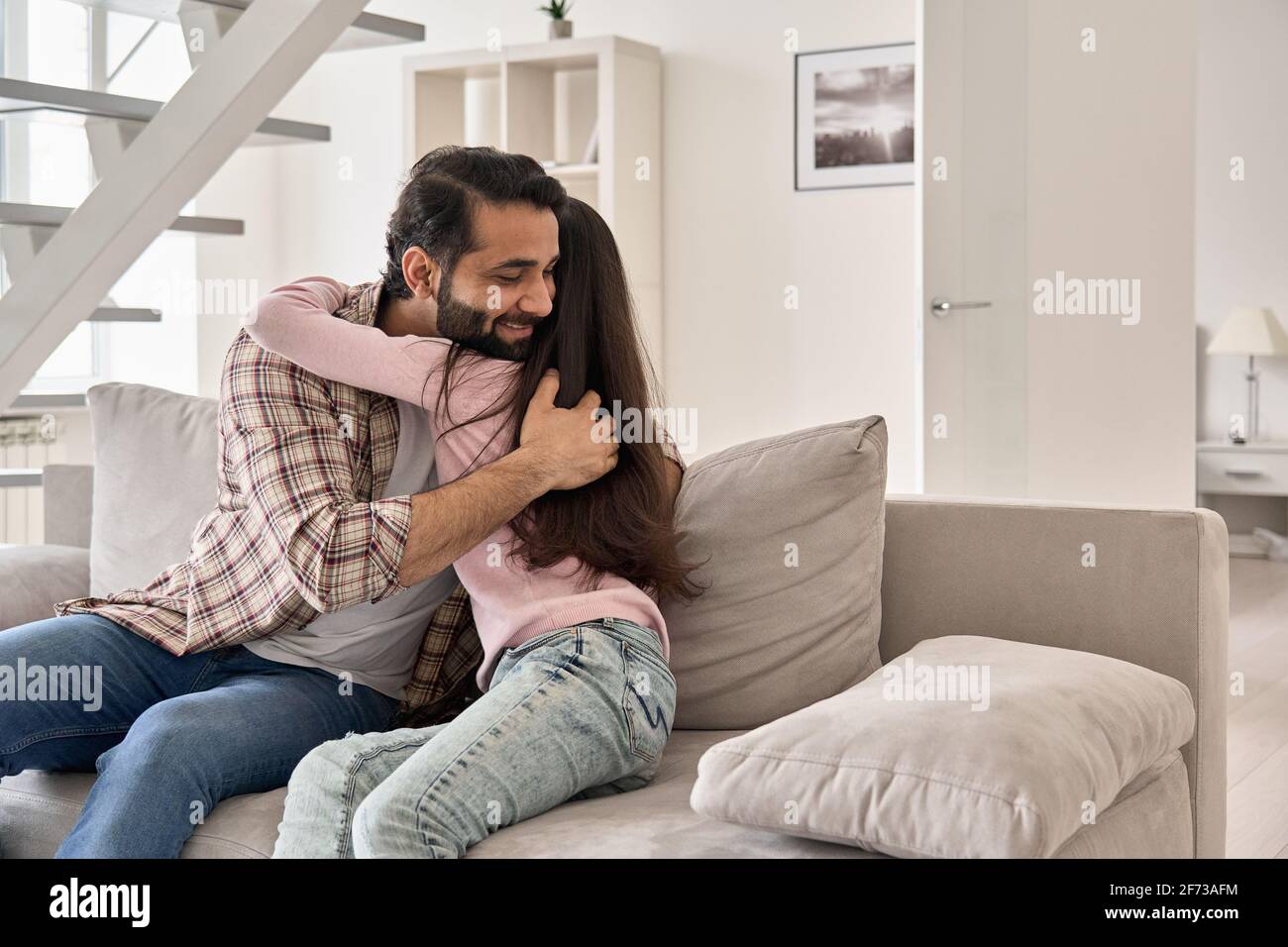 Bonne fille indienne adolescente embrassant papa à la maison le jour des pères. Banque D'Images