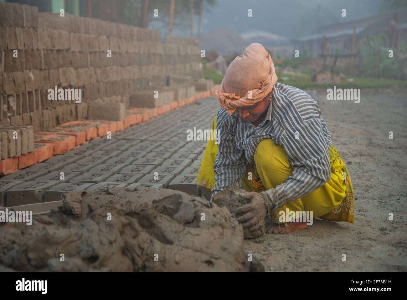 Un travailleur porte des briques au Brickfield à Khulna, au Bangladesh. Banque D'Images