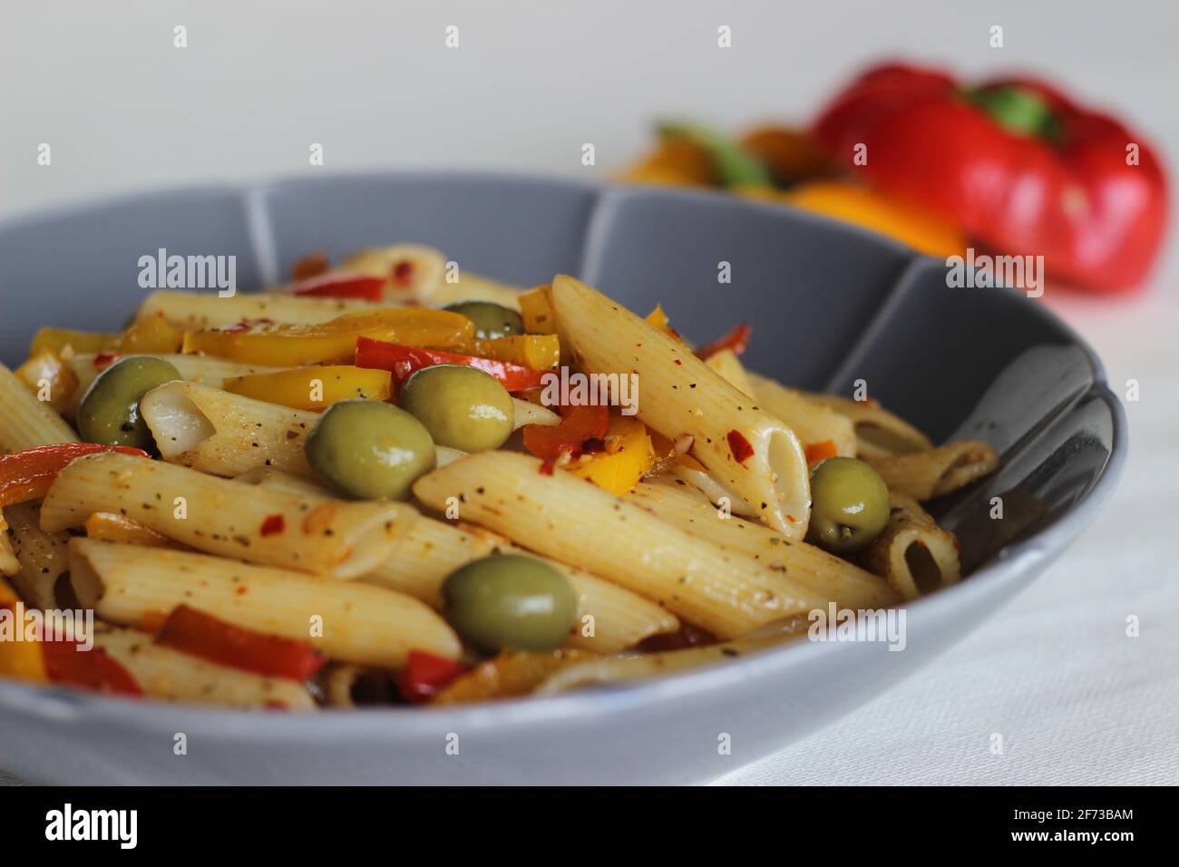 Pâtes au beurre avec légumes. Pâtes bouillies sautées dans du beurre avec de l'ail et de l'origan et sautées d'olives et de poivrons sautés. Prise de vue en blanc Banque D'Images