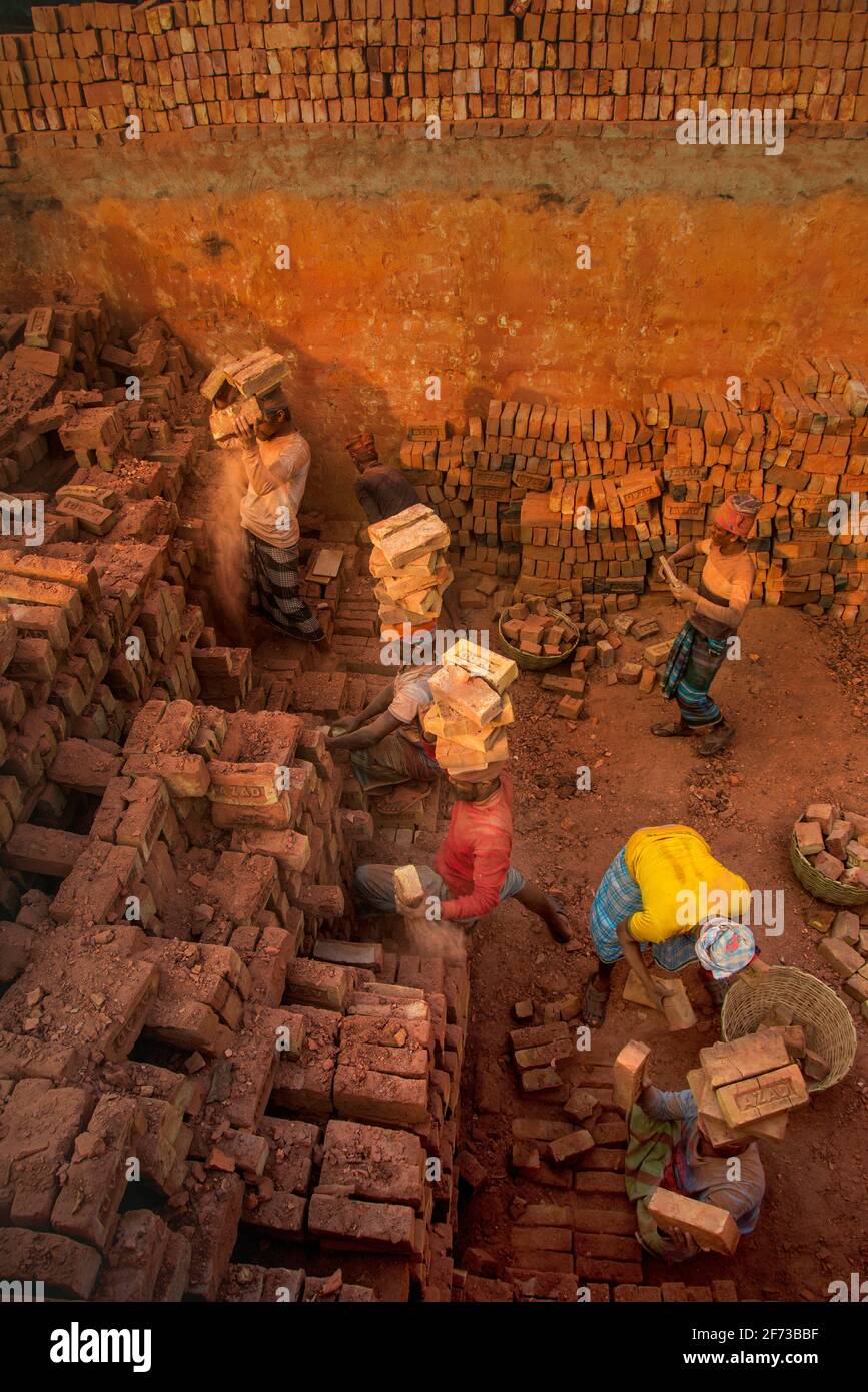 Un travailleur porte des briques au Brickfield à Khulna, au Bangladesh. Banque D'Images