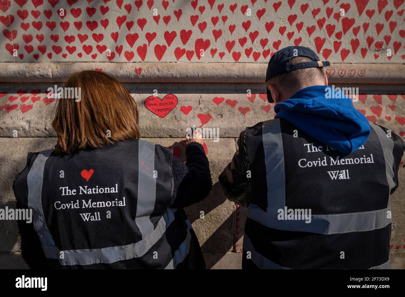 Londres, Royaume-Uni. 4 avril 2021. Les volontaires tirent le cœur le dimanche de Pâques sur un mur à Lambeth, près de la Tamise, chaque cœur représentant une personne décédée pendant la pandémie de coronavirus au Royaume-Uni. Appelé le mur commémoratif national Covid, il a été créé par le groupe Covid-19 Bereaved Families for Justice avec des travaux qui débutent il y a une semaine et s'étendra sur un demi-mile à la fin. Credit: Stephen Chung / Alamy Live News Banque D'Images