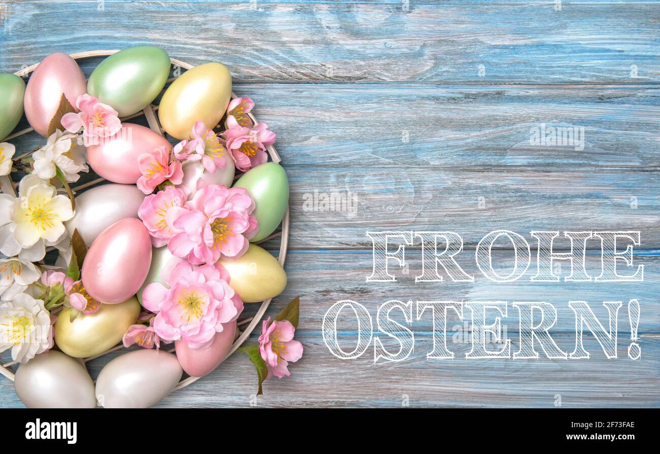 Décoration oeufs de Pâques avec fleurs de printemps. Joyeuses Pâques en allemand Banque D'Images