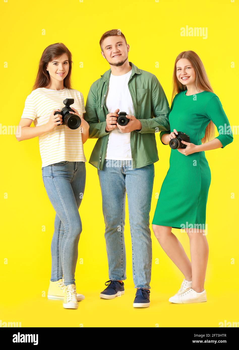 Groupe de jeunes photographes sur fond de couleur Banque D'Images