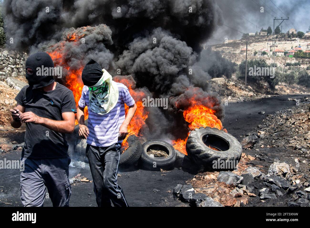 Conflit israélo-palestinien. Des manifestants palestiniens brûler des pneus au cours d'affrontements avec l'armée israélienne à l'Kafr Qaddum démonstration - Palestine Banque D'Images